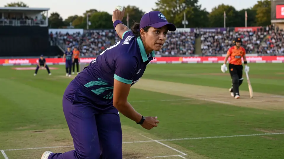 Close sideline view of a batter playing a firm drive through the off side during a day fixture, with shallow depth of field
